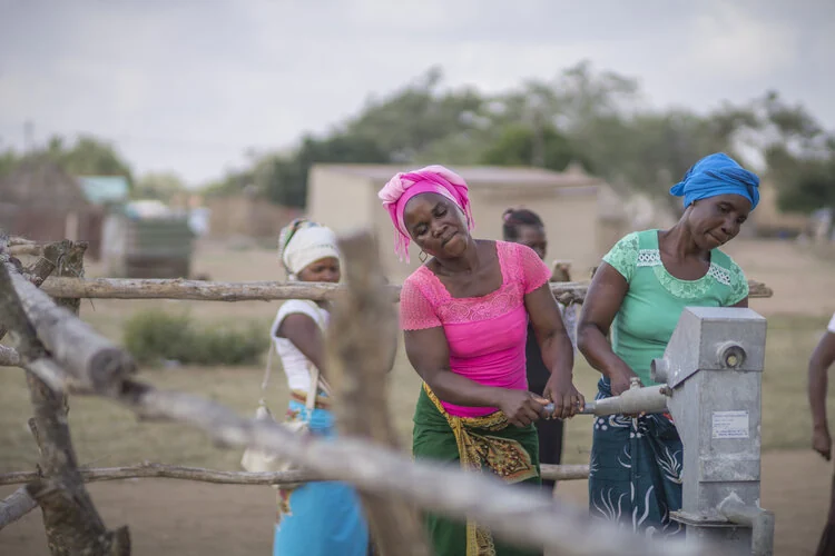 Women collecting clean water from a community hand pump