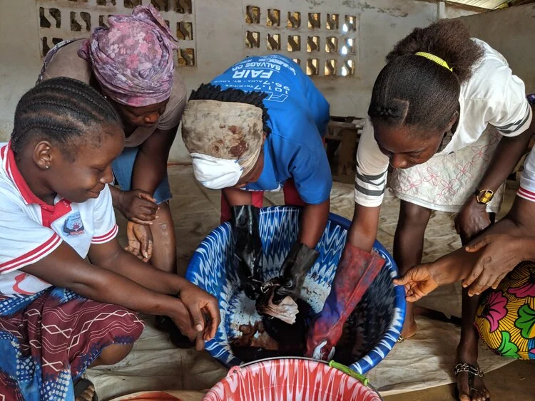 Women working together around a bowl in a workshop